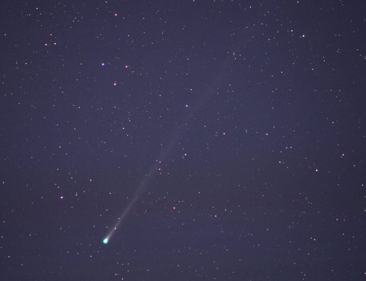 Комета C/2025 R3 (PanSTARRS) низько в лівій нижній частині кадру; від її яскравої голови вгору по діагоналі простягається довгий тонкий хвіст серед густого поля зір.